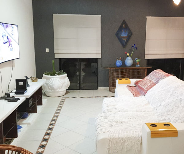 Sala de estar com TV por assinatura e mesa de jantar